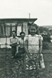 Photo taken by the neighbours over the fence showing the prefab with a young girl standing in front of the fence